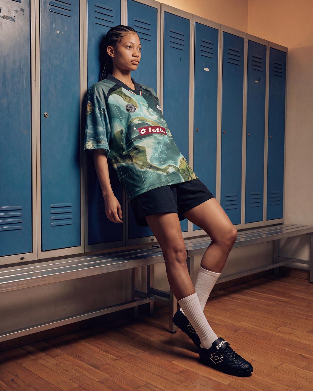 Girl leaning on a wall of lockers wearing the new LOTTO X Joshua Joseph jersey